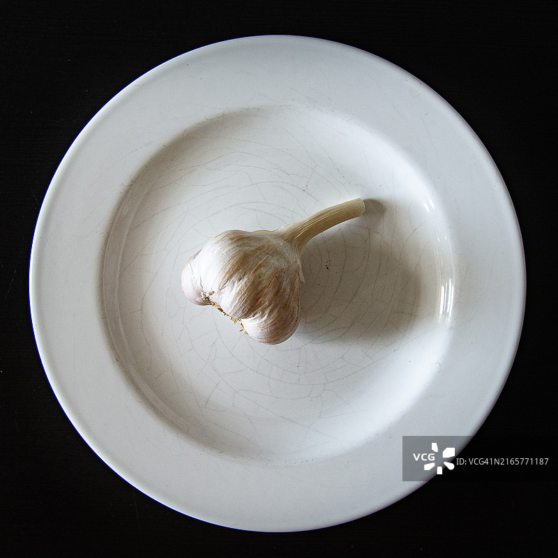 白色盘子上放着一颗蒜头图片素材