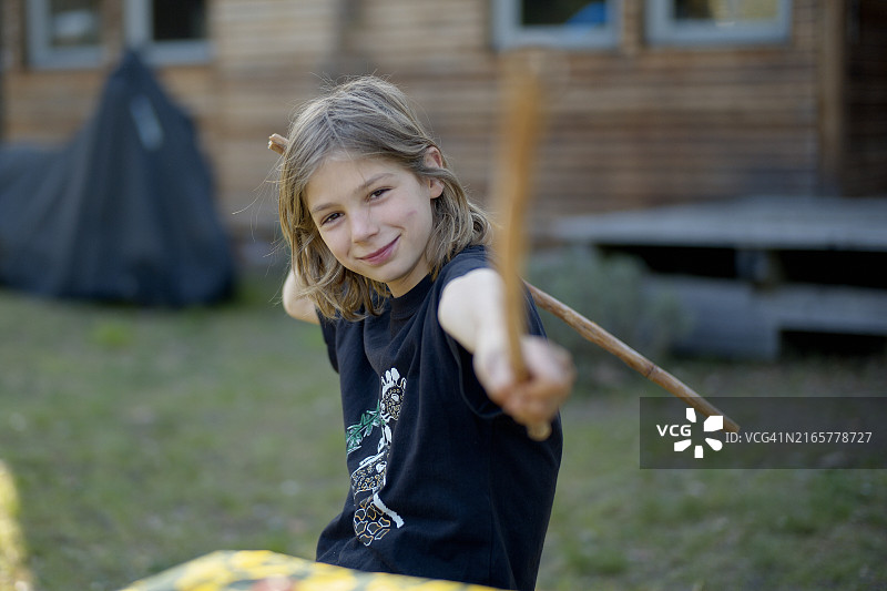 后院里微笑的儿童拿着木棍伸出手图片素材