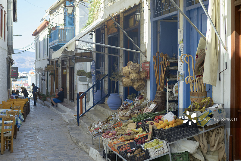地中海小镇的传统街头市场，展示着新鲜农产品和充满活力的蓝色店面图片素材