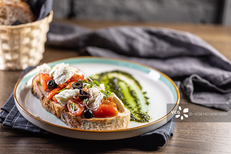 卡普雷塞三明治，配番茄、马苏里拉奶酪、橄榄和罗勒香蒜酱，作为早餐或早午餐图片素材