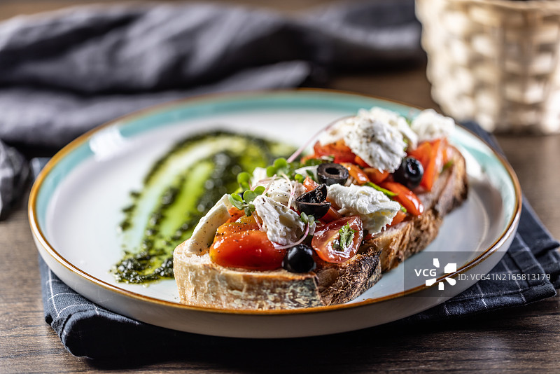 卡普雷塞三明治，配番茄、马苏里拉奶酪、橄榄和罗勒香蒜酱，作为早餐或早午餐图片素材