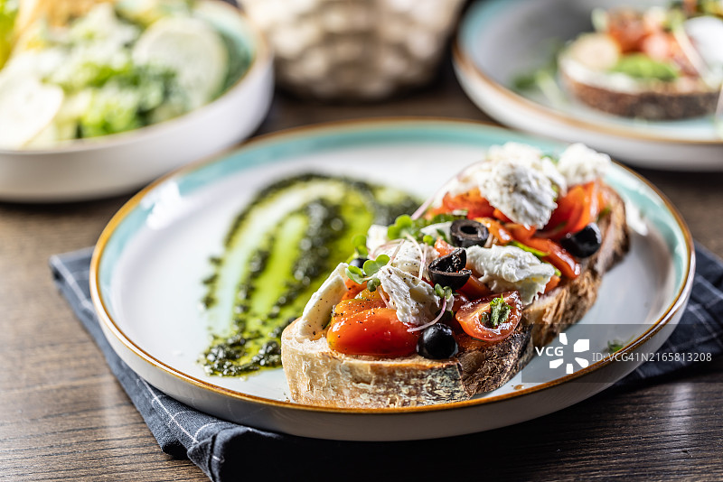 卡普雷塞三明治，配番茄、马苏里拉奶酪、橄榄和罗勒香蒜酱，作为早餐或早午餐图片素材