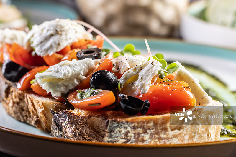 卡普雷塞三明治，配番茄、马苏里拉奶酪、橄榄和罗勒香蒜酱，作为早餐或早午餐图片素材