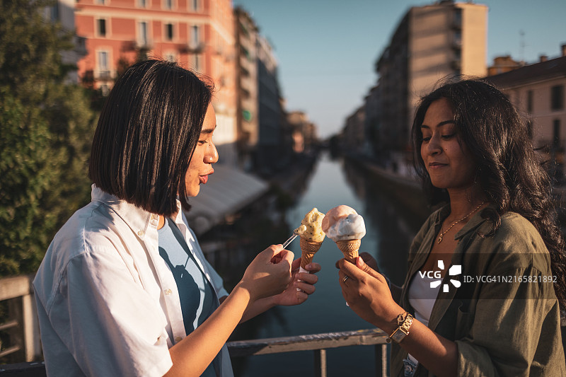 朋友们在意大利米兰运河边享用冰淇淋图片素材