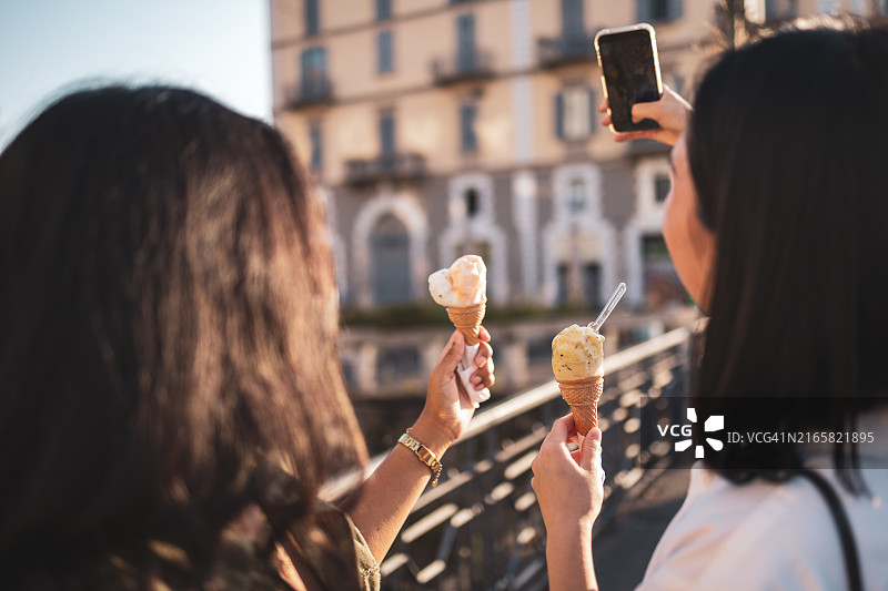 朋友们在意大利米兰享受冰淇淋和观光图片素材