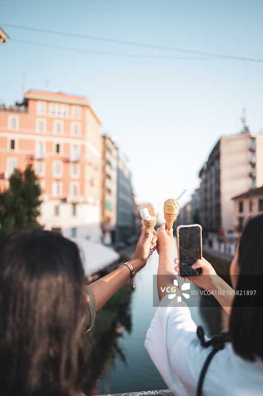 在意大利米兰，朋友们享受冰淇淋并拍照图片素材
