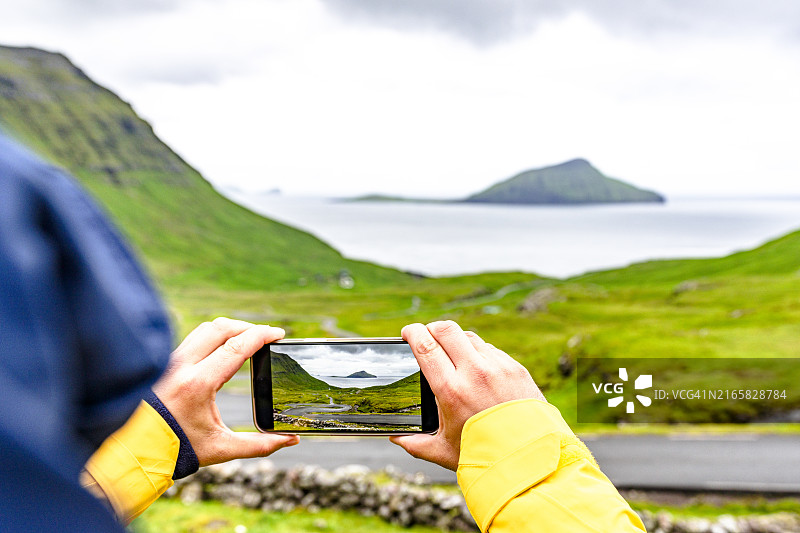 游客用智能手机拍摄悬崖图片素材