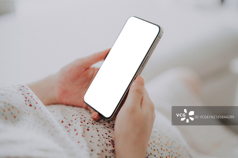 女人拿着带有空白屏幕的智能手机图片素材