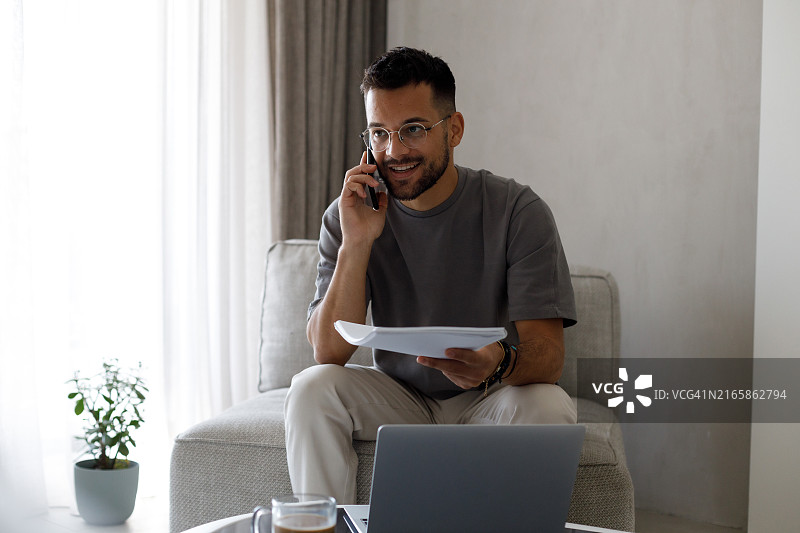 忙碌的年轻自由职业者在笔记本电脑上工作时手托着头休息图片素材