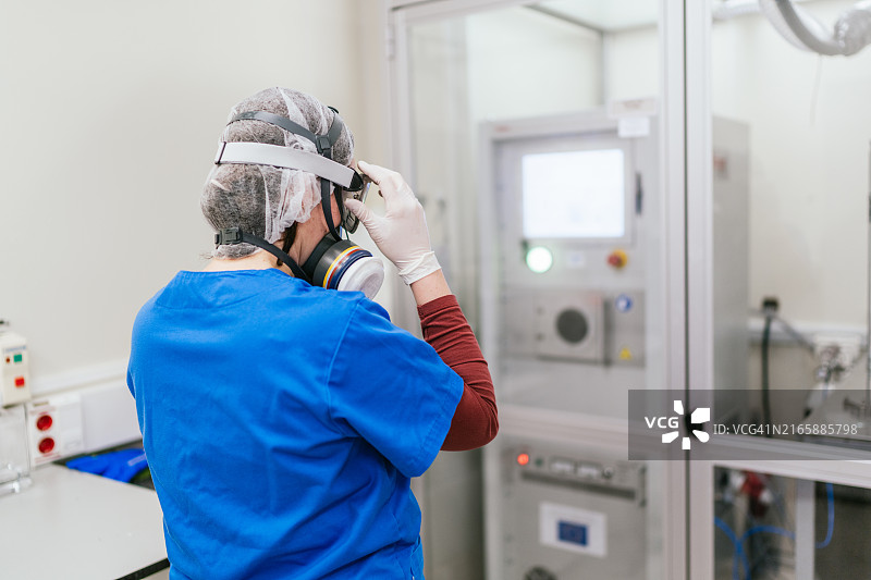 科学家戴上安全护目镜进入装有火焰色谱仪的房间图片素材