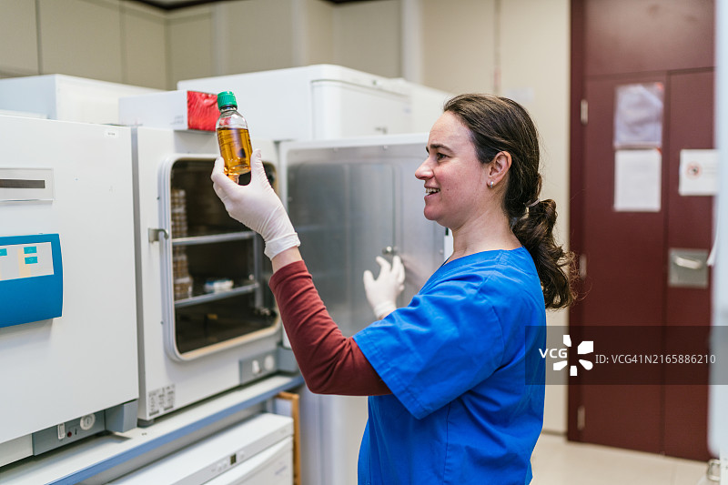 科学家在细胞治疗实验室检查瓶子图片素材