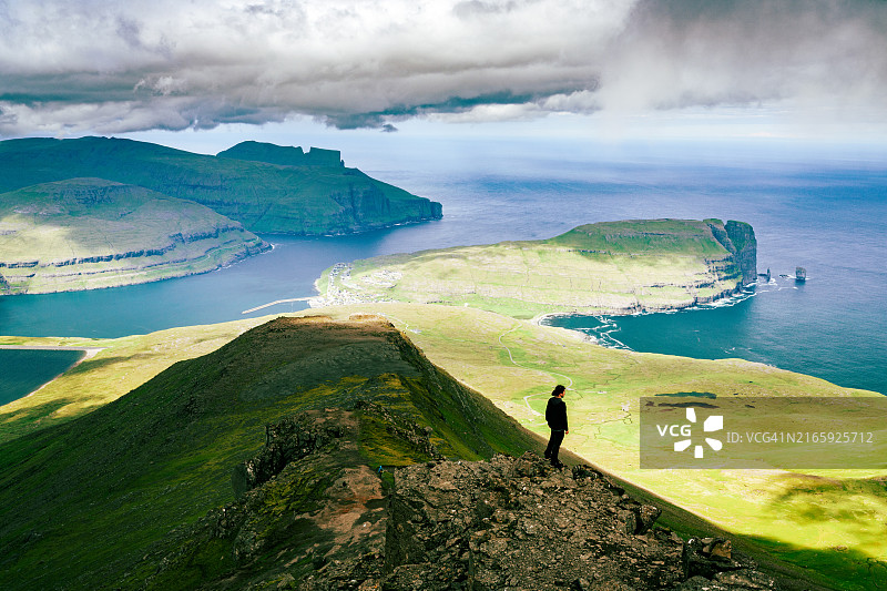男子在山顶欣赏大海的轮廓图片素材