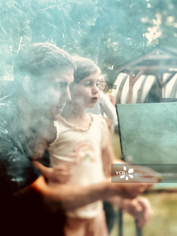 营火旁抱着小女孩的年轻男人图片素材