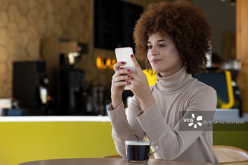 年轻女人在咖啡店用手机图片素材
