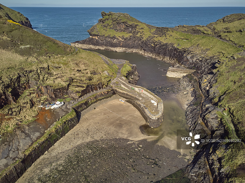 英国康沃尔郡博斯卡斯尔狭窄海港和周围悬崖的航拍图片素材