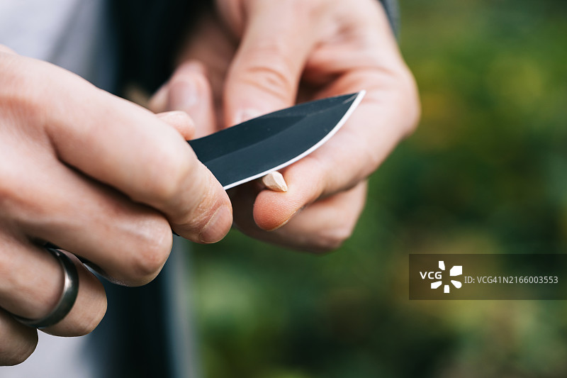 男人用刀削木棍图片素材