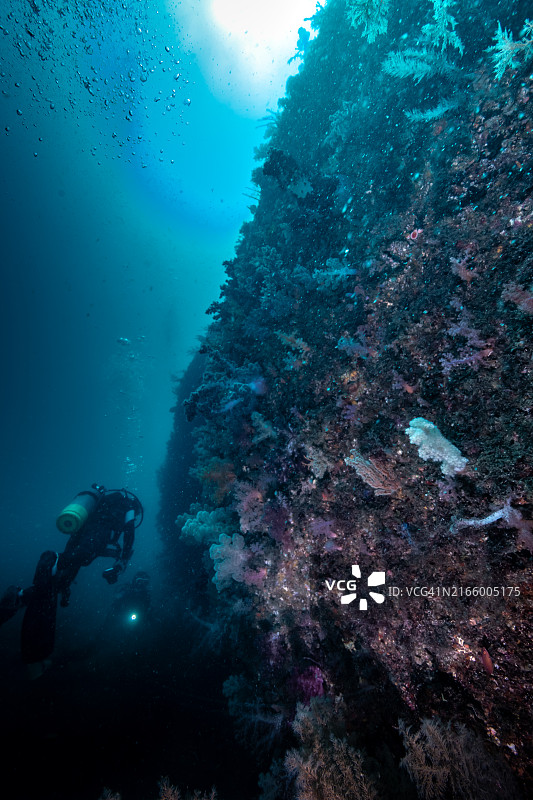潜水员在水下悬崖边游泳图片素材