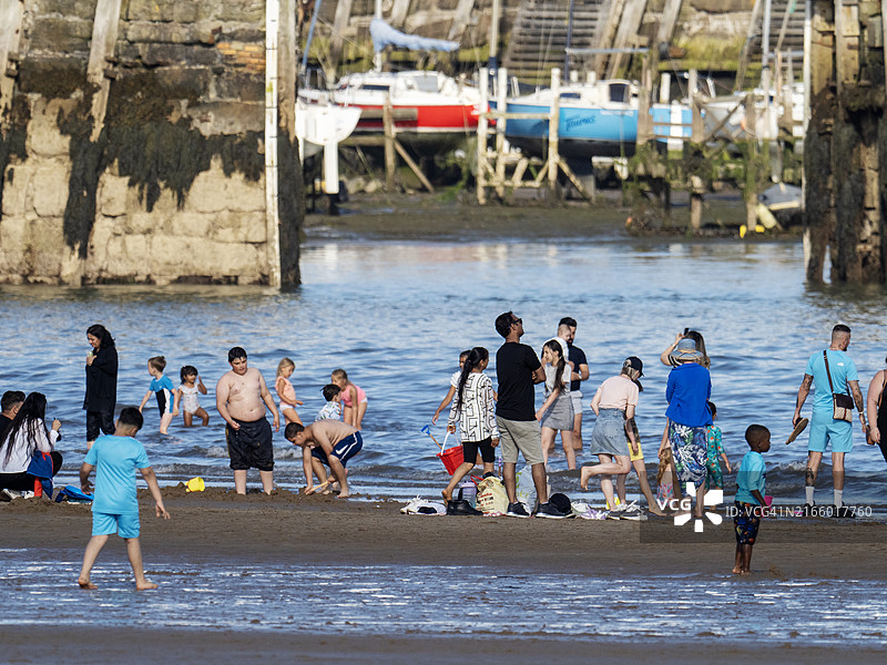 英国约克郡斯卡伯勒海滩上的多元文化人群图片素材