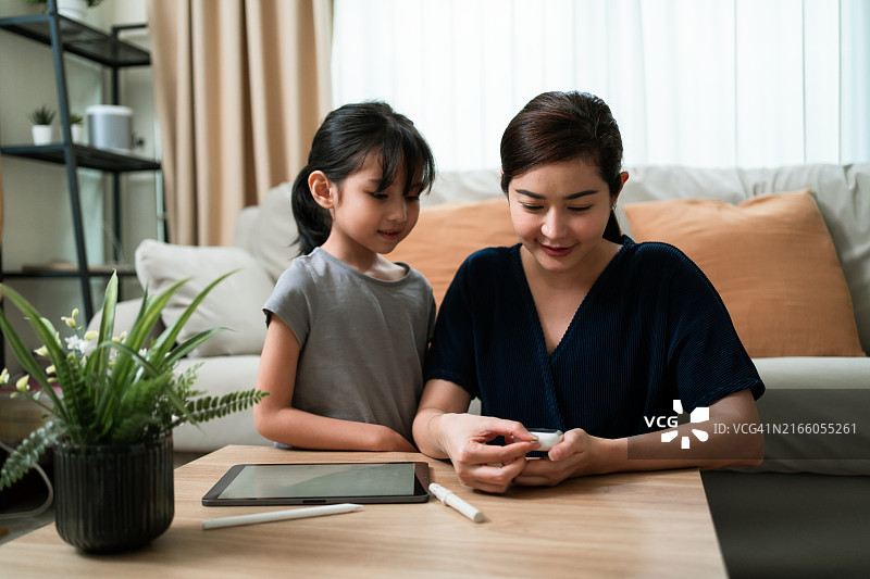 母女一同学习使用血糖仪图片素材