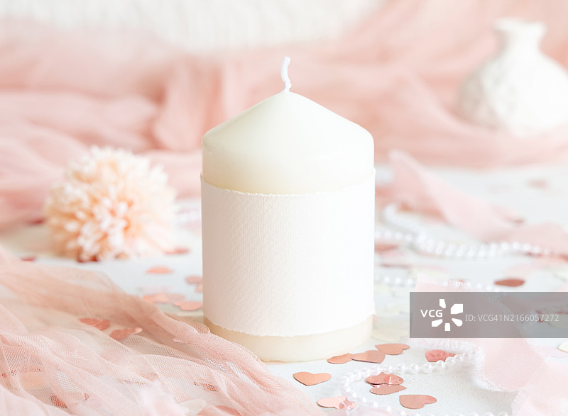 带空白标签的蜡烛，粉色装饰，白色桌子上的心形和薄纱，模型图片素材