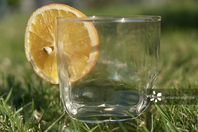 田野上饮用玻璃杯中的橙子切片特写图片素材