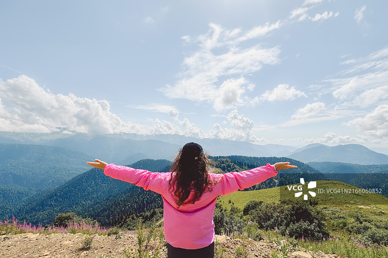 张开双臂，欣赏风景如画山景的女人图片素材