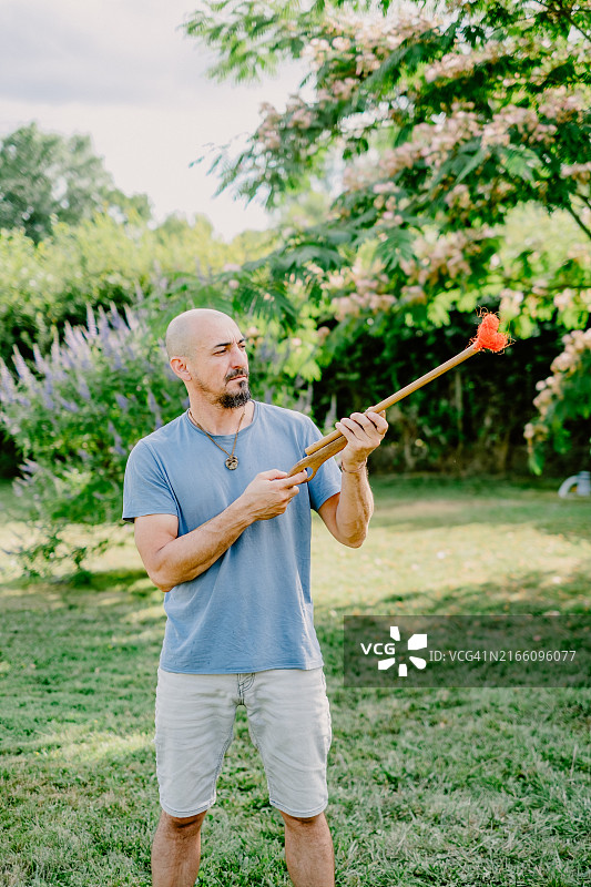男人拿着一把末端带心形的假枪图片素材