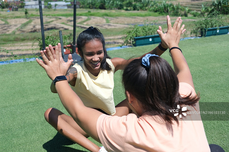 锻炼后击掌的两位快乐的女性朋友图片素材