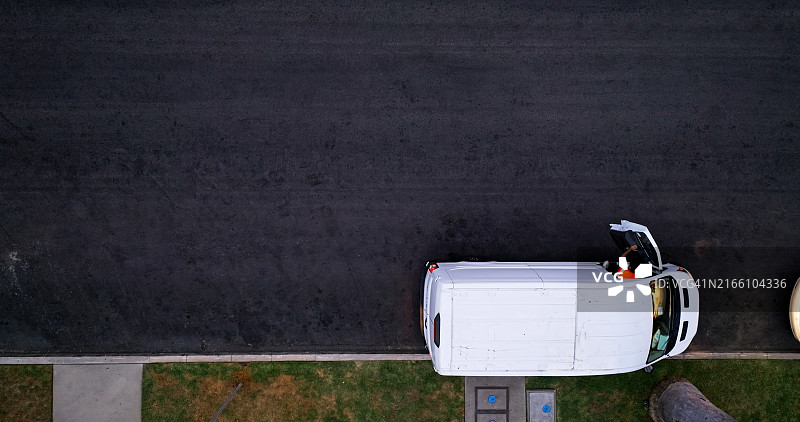 配送员走出白色货车的鸟瞰图图片素材