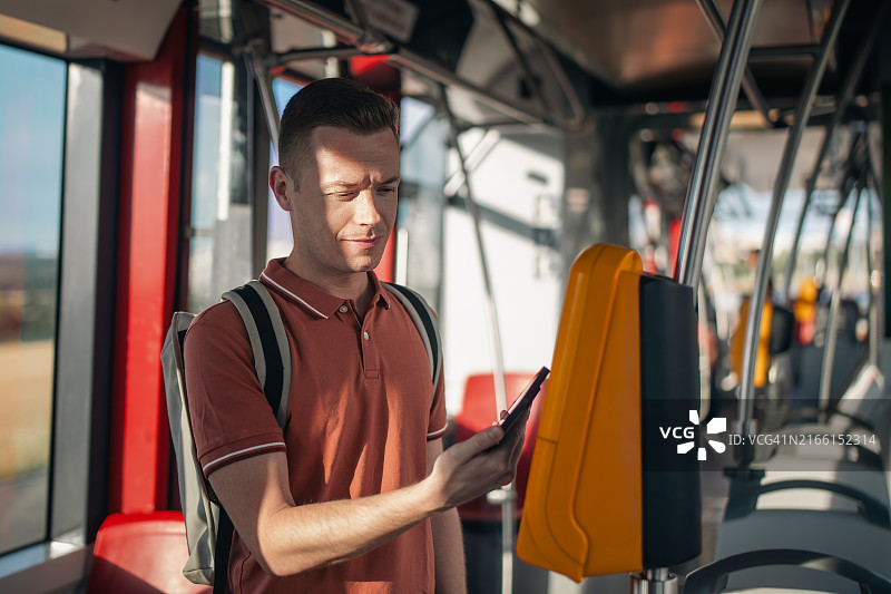 男子使用智能手机进行非接触式支付图片素材