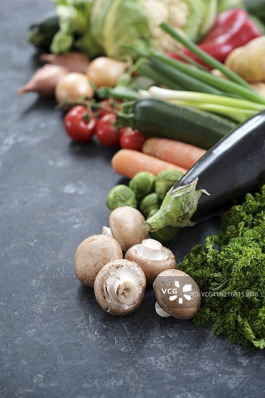 深灰色石板表面上的大量新鲜蔬菜，均衡饮食的健康食品概念图片素材