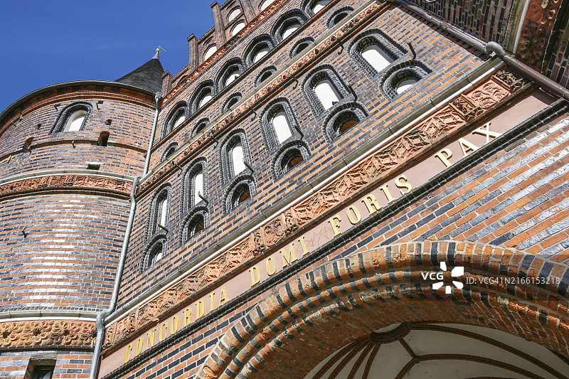 德国吕贝克霍尔斯滕门局部，红色砖砌建筑的中世纪地标，金色铭文Concordia domi foris pax（内部和谐，外部和平），由下往上拍摄图片素材
