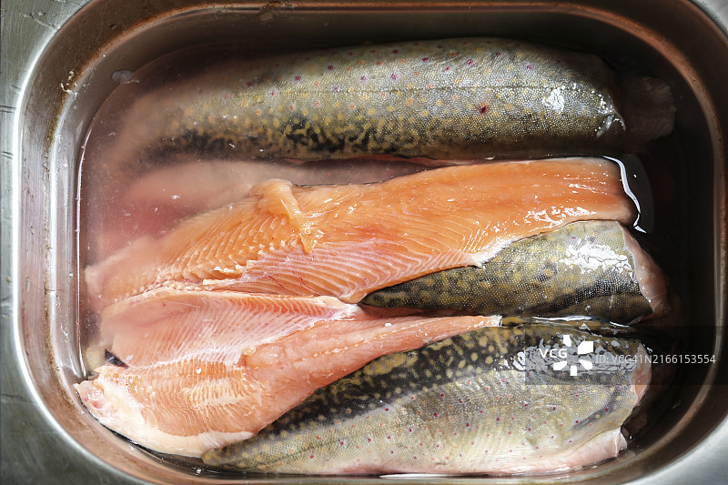 不锈钢容器中已去骨清洗的嘉鱼，可用于专业厨房烹饪图片素材