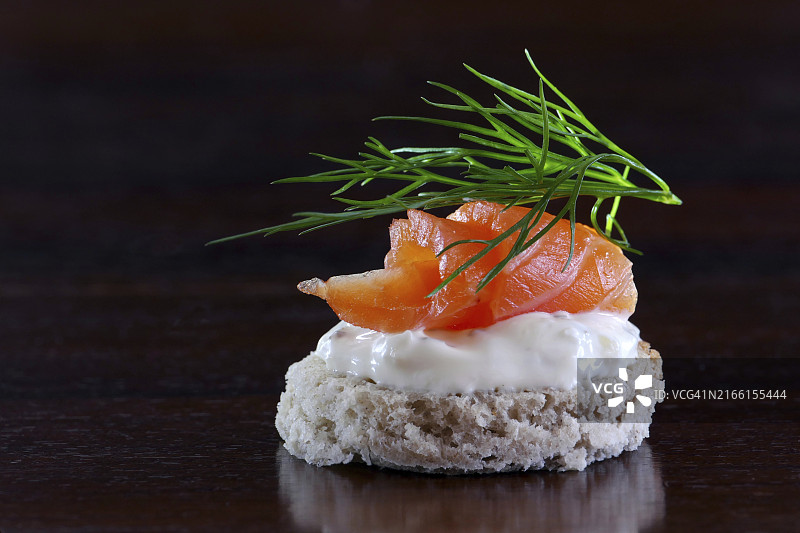 三文鱼奶油莳萝小吃，深棕色木纹背景含文案空间，特写图片素材