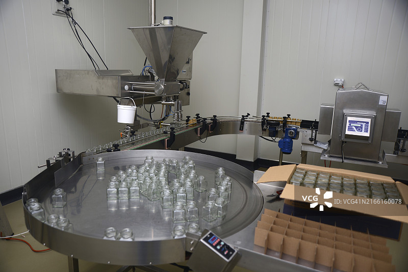 蜂蜜加工厂包装线上的罐装结晶蜂蜜图片素材