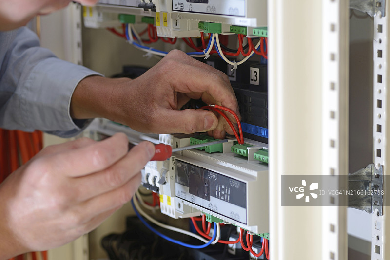 电工在新建筑中连接配电盘图片素材