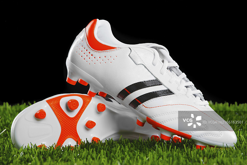 绿茵草地上的足球鞋特写图片素材