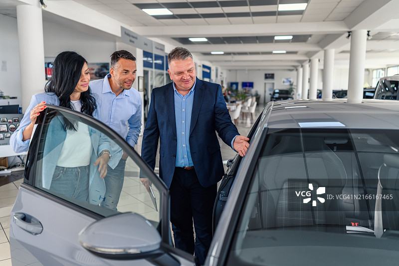 销售人员帮助顾客夫妇挑选新车图片素材