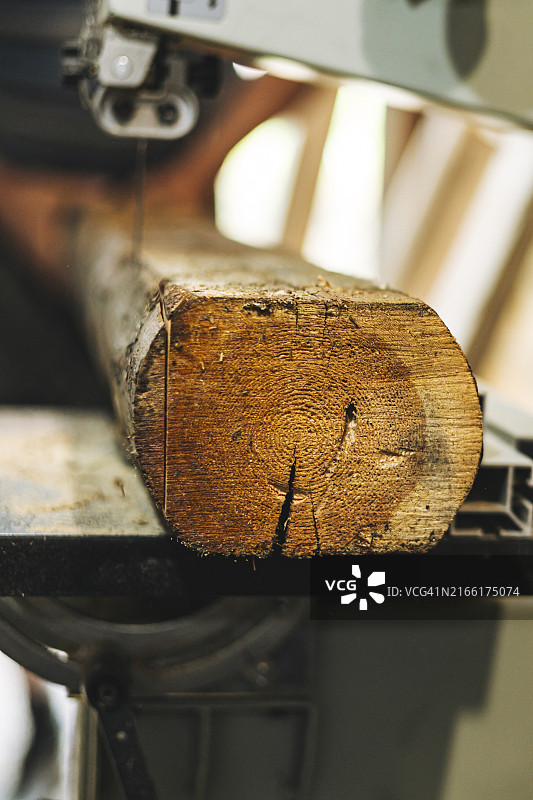 室内用锯切割木材的木工过程特写图片素材