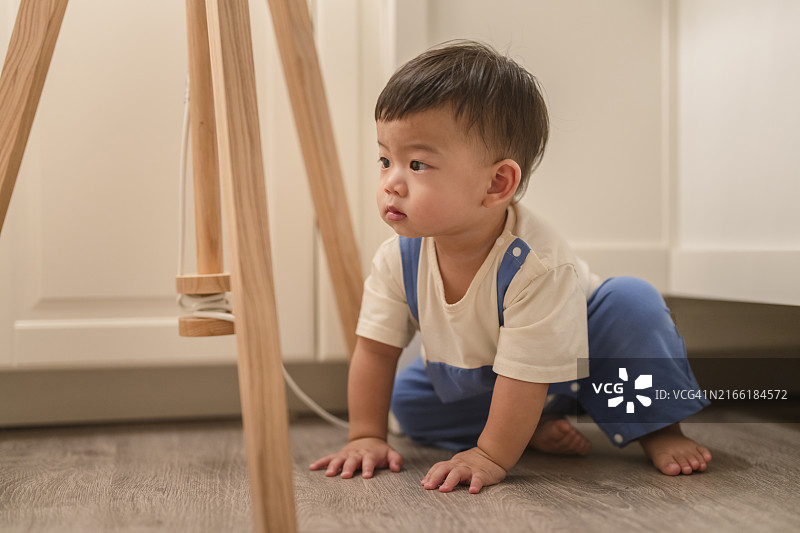 在家中地板上爬行的亚洲男婴图片素材