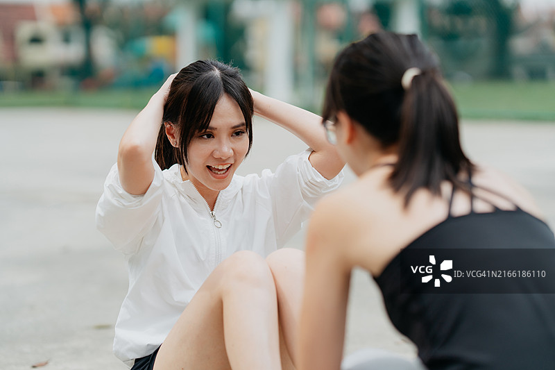 女性运动员享受伴侣仰卧起坐训练图片素材