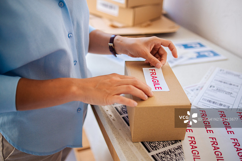 贴标签的人给易碎盒子贴上运输安全注意事项图片素材