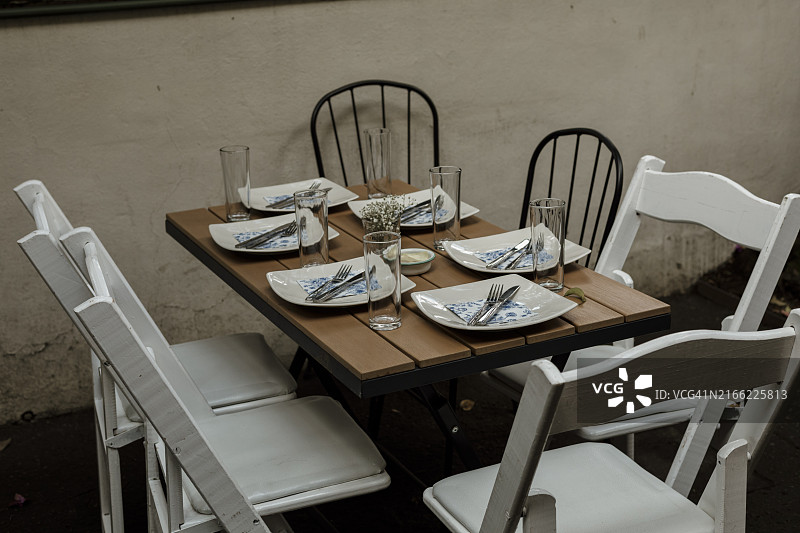 户外花园中装饰有餐具的活动餐桌图片素材