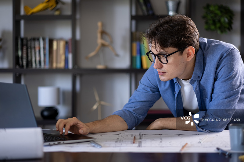在家用笔记本电脑工作的年轻男建筑师图片素材