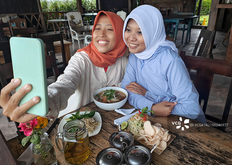 两名印度尼西亚穆斯林女性在餐厅自拍图片素材