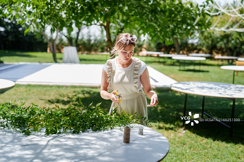 团队为婚礼活动制作花卉装饰的瞬间图片素材