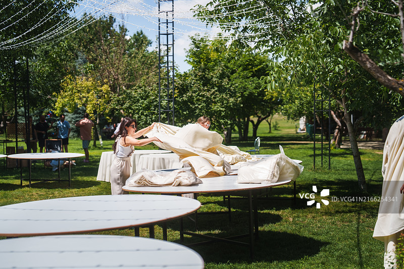 婚礼策划团队正在为婚宴铺设桌布图片素材