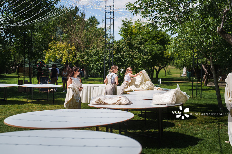 婚礼策划团队正在为婚宴铺设桌布图片素材