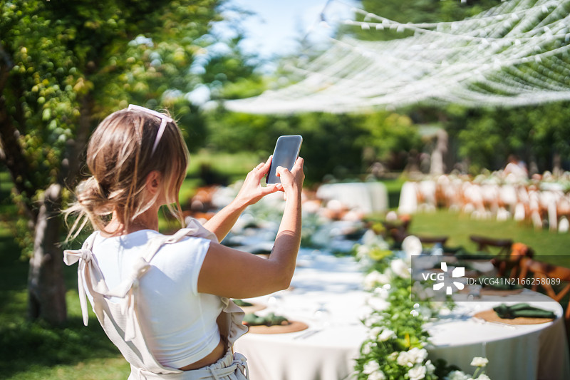 婚礼策划师用手机拍摄餐桌图片素材