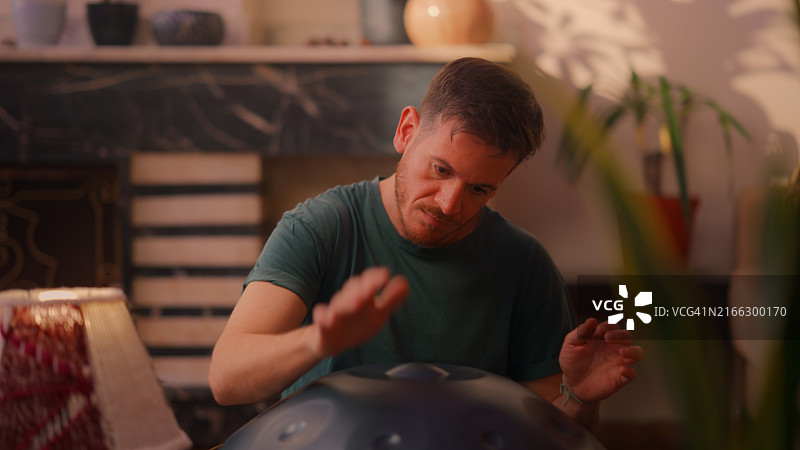 男人坐在地上演奏手碟图片素材